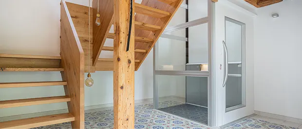Kleiner Plattformaufzug in Wohnhaus mit Holztreppe