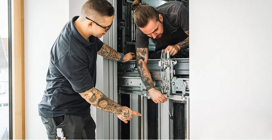 Techniker montieren Aufzugskomponenten gemeinsam
