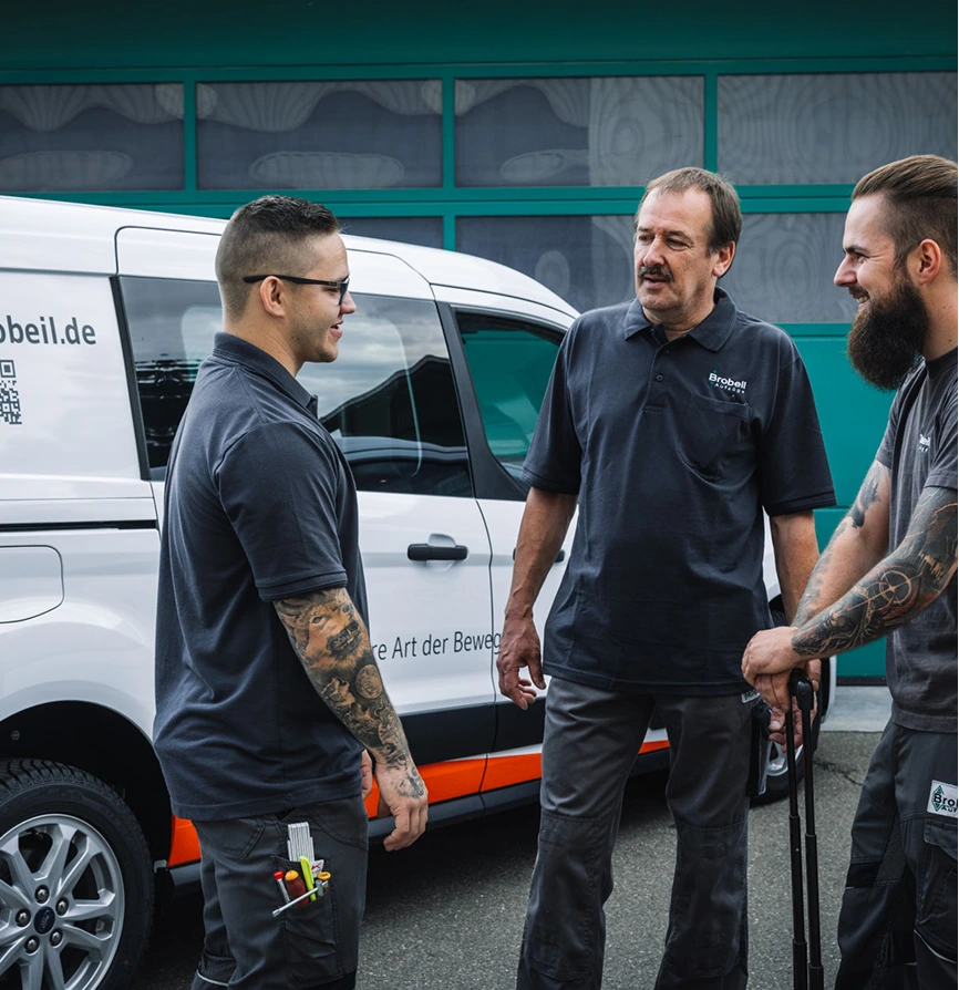 Servicetechniker im Gespräch vor Firmenfahrzeug