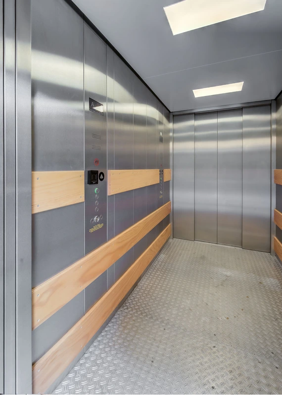 Innenansicht eines Aufzugs mit Holz- und Edelstahldesign